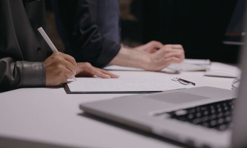 osoba zapisuje nešto na papiru